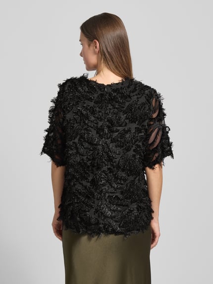 Vrouwenmodel draagt T-shirt met Zierbesatz Modell 'VILLA' van FREE/QUENT, zwart, semi-transparant, losse fit, detailrijke textuur, half-mouw, ruglengte 60 cm, Ganzkörperansicht Rückansicht.