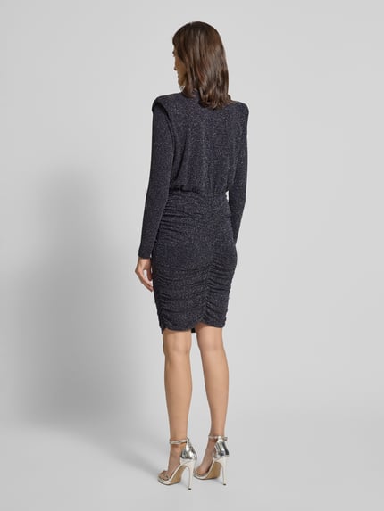 Vrouwenmodel draagt knielanges Kleid mit Schulterpolstern van Rich & Royal, glanzende stof, getailleerd, ruglengte 108 cm, rugaanzicht.