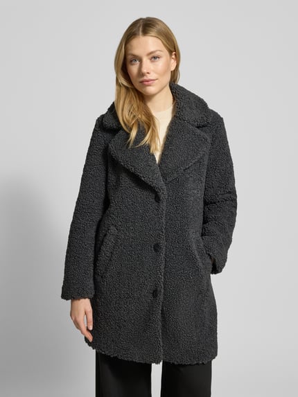Frauenmodel trägt Regular Fit Teddy-Mantel mit Umlegekragen Modell 'KYLIE' von Vero Moda, unifarben, strukturierte Textur, Ganzkörperansicht von vorne.