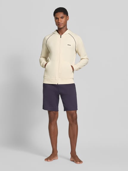 Mannelijk model draagt Regular Fit Sweatshirt aus Baumwoll-Mix van BOSS in beige met donkere naden, Heren sweatjack, volledig frontaal zicht.