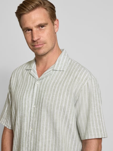 Männermodel trägt Regular Fit Freizeithemd aus Leinen-Baumwoll-Mix von MCNEAL, hellgrün mit weißen Streifen, Nahaufnahme Oberkörper, Reverskragen, Knopfleiste, Rückenlänge 72 cm, Schulterbreite 53 cm, Ärmellänge 26 cm.