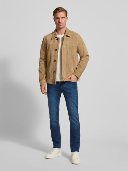 Męski model nosi Slim Fit Jeans mit 5-Pocket-Design od Christian Berg Men, niebieski denim, bawełna bio z elastanem, widok całej sylwetki z przodu.