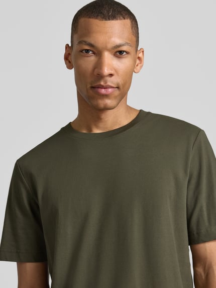 Männermodel trägt Regular Fit T-Shirt aus Baumwoll-Mix von Tom Tailor, Optik: Unifarben, Rundhals, Kurzarm, Piqué, Nahaufnahme Oberkörper.