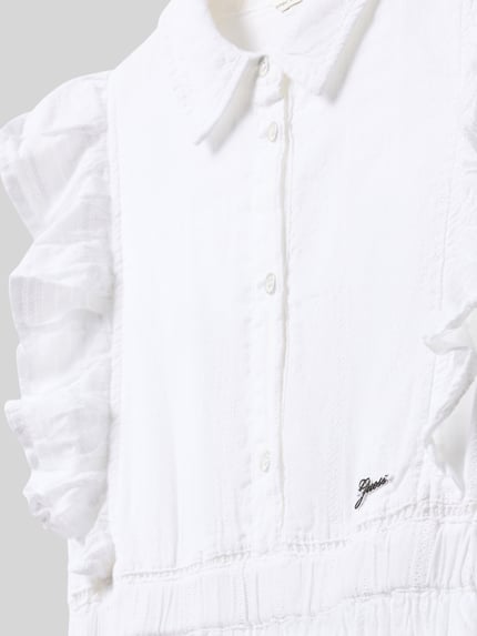 Mädchen trägt Knielanges Kleid mit Schmetterlingsärmeln von Guess aus weißem Baumwoll-Mix mit Kentkragen, Label-Detail, Rock mit Häkelspitze, taillierter Schnitt, Nahaufnahme Oberkörper.