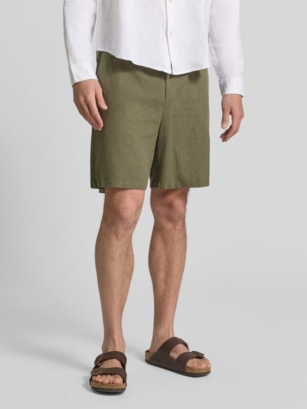 Männermodel trägt Leinenshorts mit elastischem Bund von GAP aus Leinen-Baumwoll-Mix in Olive, Loose-Fit, mit Kordelzug, Eingrifftaschen, Gesäßtaschen, Ganzkörperansicht von vorne.