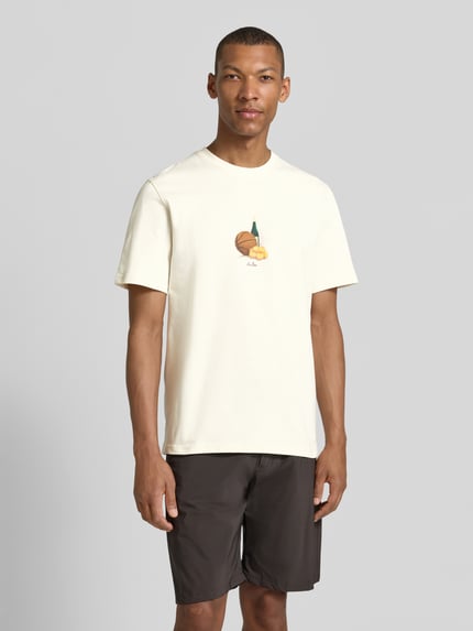 Männermodel trägt T-Shirt mit Label-Detail von Les Deux, helle Farbe, Reine Baumwolle, Gerader-Schnitt, Rundhalsausschnitt, Rückenlänge bei Größe M: 65 cm, Ganzkörperansicht von vorne