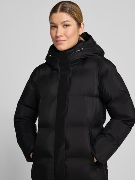 Kobiece modelka nosi czarny Steppmantel mit Reißverschlusstaschen Modell 'MAYLA4' von khujo, krój regular fit, z kapturem, zbliżenie na górną część ciała.