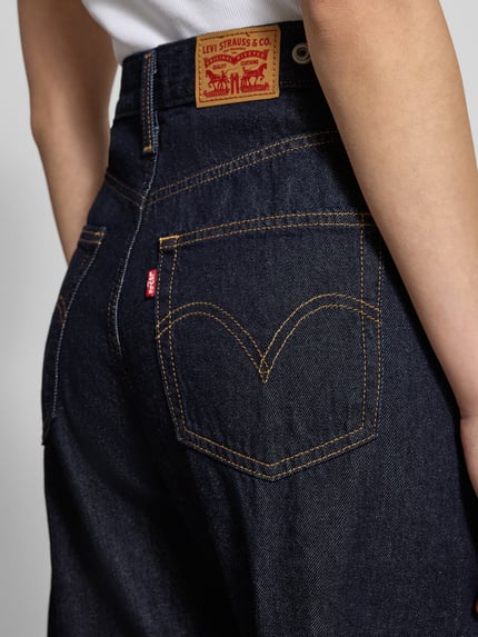Frauenmodel trägt Barrel Fit Jeans mit Eingrifftaschen von Levi's®, dunkelblauer Denim, sichtbare Nähte, Nahaufnahme Rückansicht.
