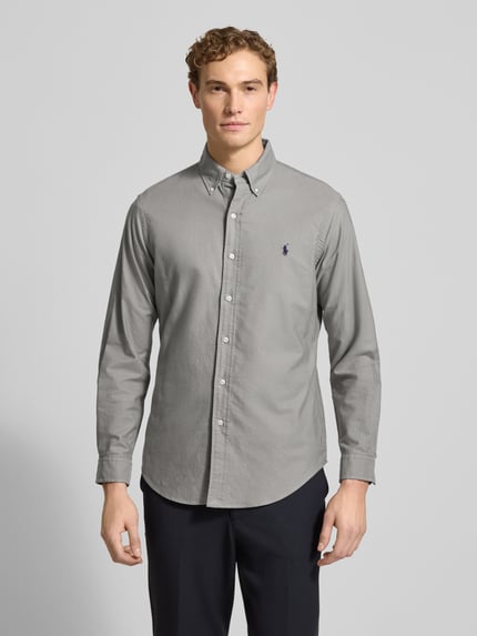 Męski model nosi Freizeithemd mit Knopfleiste od Polo Ralph Lauren, czysta bawełna, krój regular fit, długość tyłu w rozmiarze M 80 cm, szerokość ramion w rozmiarze M 45 cm, długość rękawa w rozmiarze M 64 cm, odcień szarości, gładka tekstura, guzik, naszywka z logo, całkowity widok z przodu