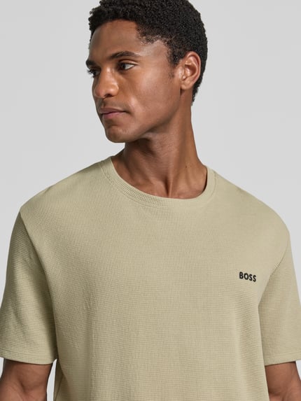 Männermodel trägt Regular Fit T-Shirt aus Baumwoll-Mix von BOSS, unifarben, Waffelstruktur, kurzarm, Rundhals, Nahaufnahme Oberkörper.