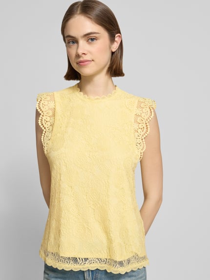Frauenmodell trägt Shaped Fit Blusentop mit Spitzenbesatz Modell 'OLLINE' von Pieces, Optik: Unifarben, Muster: Floral, Ganzkörperansicht von vorne.