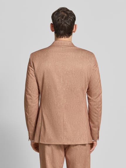 Męski model nosi Regular Fit Sakko mit Viskose-Anteil Modell 'Calvin' od CG - Club of Gents, kolor beżowy, całkowity widok z tyłu. Sakko z elastycznego materiału, kieszeń na piersi, detal z logo, kieszenie z patkami, zapięcie na 2 guziki, długość pleców w rozmiarze 50: 74 cm, szerokość ramion w rozmiarze 50: 45 cm, długość rękawa w rozmiarze 50: 65 cm.