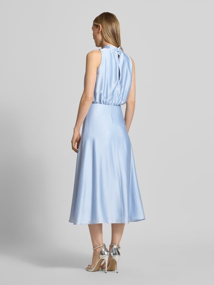 Frauenmodel trägt Cocktailkleid mit Stehkragen von Swing in Hellblau, taillierte Passform, Midikleid, Rückenreißverschluss, Unterkleid, Rückenlänge 126 cm, Brustweite 34 cm, Ganzkörperansicht Rückansicht.