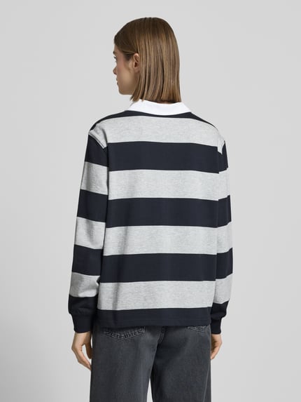 Frauenmodel trägt Polo-Langarmshirt mit Streifen und kontrastiger Knopfleiste von Review, reine Baumwolle, Regular Fit, Rückansicht.