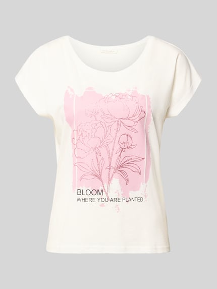 Frauenmodel trägt Regular Fit T-Shirt aus Viskose-Mix mit Floraler-Print von Christian Berg Woman, weiß mit rosa Farbfeld, Rundhalsausschnitt, Rückenlänge 55 cm, Ganzkörperansicht von vorne.