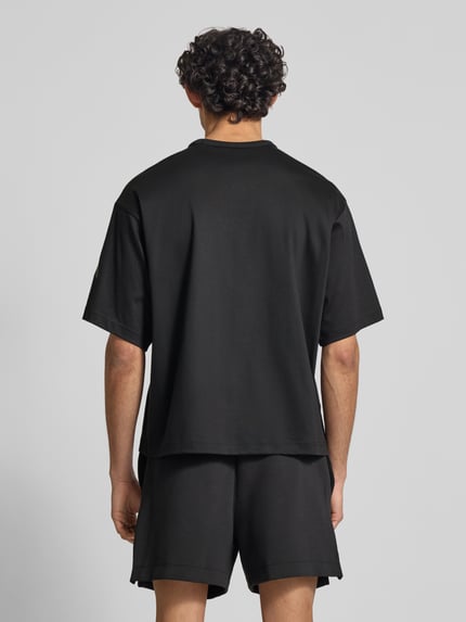 Mannelijk model draagt Relaxed Fit T-Shirt uit puur katoen van adidas Sportswear, look: effen, pasvorm: relaxed fit, korte mouw, materiaalverwerking: jersey, detailopname rugaanzicht.