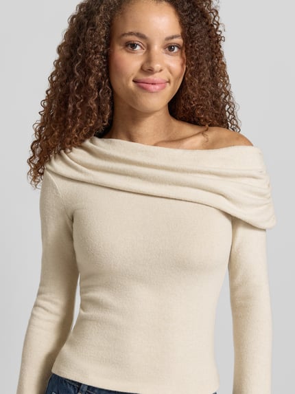 Vrouwenmodel draagt shirt met lange mouwen van materiaalmix met viscose, nauwsluitend model, asymmetrische hals, trompetmouwen, model 'Mindy' van Gina Tricot, ruglengte maat S 51 cm, Nahaufnahme Oberkörper.