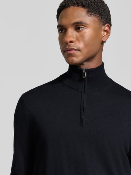 Männermodel trägt Modern Fit Troyer aus reiner Schurwolle Modell 'Dario' von JOOP! COLLECTION in dunklem Blau, Nahaufnahme Oberkörper.