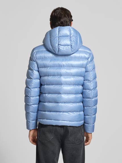 Männermodel trägt hellblaue Steppjacke mit Kapuze, Zweiwege-Reißverschluss, Modell 'ADAMS' von Blauer USA, Ganzkörperansicht Rückansicht. Rückenlänge 66 cm, Schulterbreite 44 cm, Brustweite 53 cm, Ärmellänge 65 cm, Regular Fit, glänzende Textur.