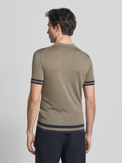 Męski model nosi Slim Fit Poloshirt aus Lyocell-Seide-Mix von GUESS, paski w kontrastowym kolorze, model 'LARRY', krój slim fit, kołnierzyk polo, listwa guzikowa, długość tyłu w rozmiarze M: 67 cm, gładka tekstura, jednolity kolor, ciemne paski na rękawach i u dołu, widok całej sylwetki od tyłu.