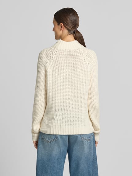 Frauenmodel trägt Strickpullover aus Kaschmir-Baumwoll-Mix Modell 'LONA' von 0039 Italy, cremefarben, lockere Struktur, Ganzkörperansicht Rückansicht. Rückenlänge 60 cm, Ärmellänge 78 cm, Regular Fit, Stehkragen.