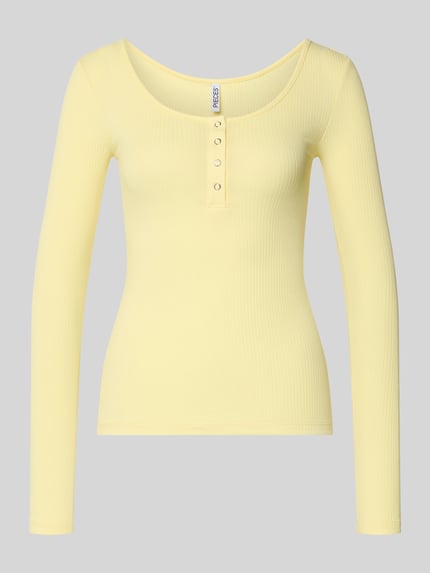Produktfoto, Slim Fit Langarmshirt aus Baumwoll-Mix Modell 'KITTE' von Pieces in Gelb, unifarben, gerippte Struktur, kurze Druckknopfleiste, Henley-Ausschnitt.