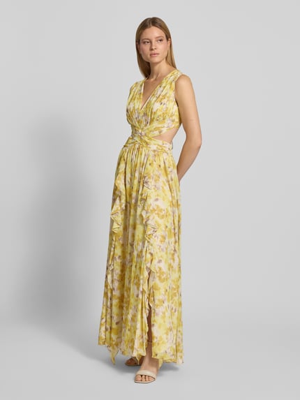 Vrouwenmodel draagt Regular Fit Maxikleid met floralem allover-print van ADLYSH met plooienlook, V-hals, mouwloos design, met ruches, cut-outs, vetersluiting; ruglengte bij maat S 52 cm, borstwijdte bij maat S 32 cm; all-over gele bloemenprint; lichte stof, vloeiende structuur; volledig zicht van voren.
