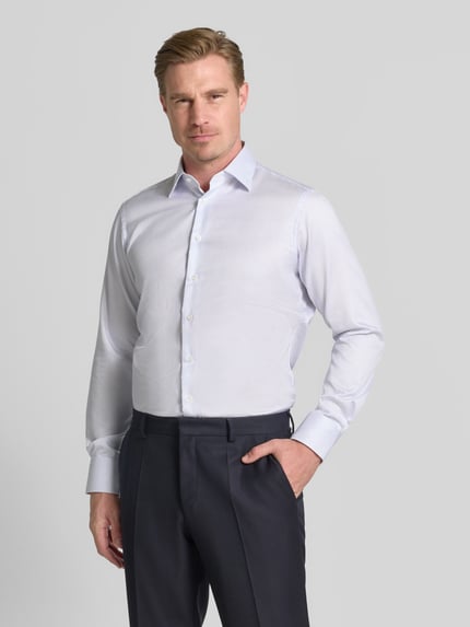Männermodel trägt Regular Fit Business-Hemd in hochwertiger Two Ply Qualität von Christian Berg Men, Unifarbenes-Design, Feintwill, Reine Baumwolle, Haifischkragen, Ganzkörperansicht von vorne.