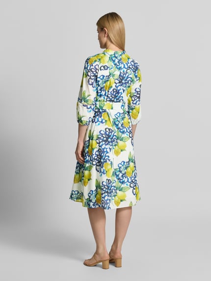Vrouwenmodel draagt Midikleid met Tunikakraag und Knopfleiste van More & More, puur katoen, a-lijn, all-over look, 3/4-mouw, ruglengte maat 36: 114 cm, borstwijdte maat 36: 44 cm, mouwlengte maat 36: 50 cm, geheel in bloemmotief, zachte kleuren, gladde stof. Ganzkörperansicht Rückansicht.