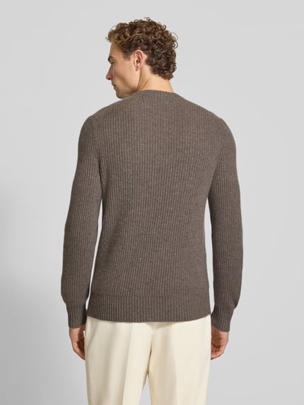 Męski model nosi sweter z dzianiny Strickpullover aus Kaschmir mit Rundhalsausschnitt od FTC Cashmere, kaszmir, prosty krój, gruby ścieg, okrągły dekolt, Długość tyłu 68 cm, Długość rękawów 72 cm, widok całej sylwetki z tyłu.