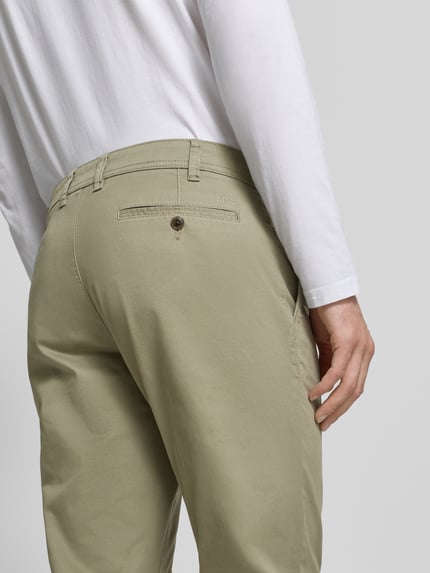 Männermodel trägt Straight Fit Chino mit Eingrifftaschen von MCNEAL aus elastischem Baumwoll-Mix, helles Beige, Detailaufnahme Rückansicht.