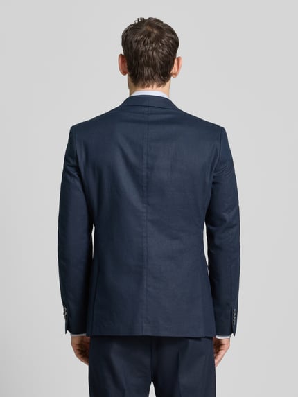 Männermodel trägt Sakko aus Leinen-Mix mit Pattentaschen von MCNEAL in Dunkelblau, Modern Fit, Rückenansicht, Ganzkörperansicht Rückansicht. Leinen-Baumwoll-Mix, Reverskragen, Knopfleiste, Brusttasche, Pattentaschen, Rückenlänge 72 cm, Schulterbreite 45 cm, Ärmellänge 63 cm bei Größe 50.