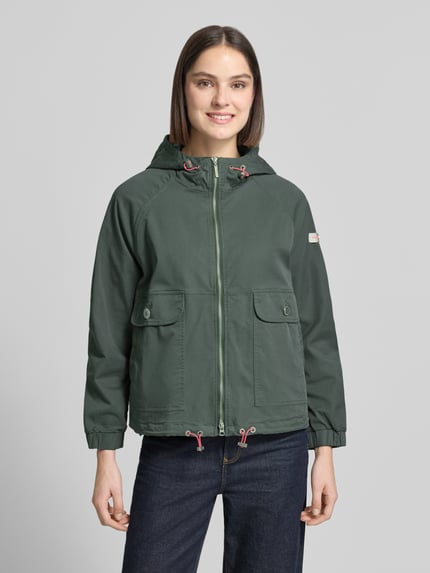 Vrouwenmodel draagt Jacke mit Zweiwege-Reißverschluss Modell 'DOLORES NEO' van Frieda & Freddies van katoenmix in recht model, groene kleur, met capuchon met koordstoppers, labelpatch op de mouw, klepzakken met knoopsluiting, elastische mouwboorden, verstelbare zoom met koordstoppers, ruglengte maat 36: 59 cm, schouderbreedte 48 cm, borstwijdte 50 cm, mouwlengte 52 cm, frontaal volledig lichaam.