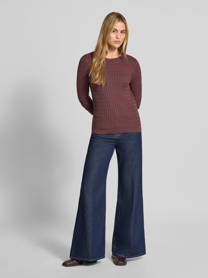 Frauenmodel trägt Slim Fit Strickpullover mit Zopfmuster von Christian Berg Woman, Baumwoll-Mix, Rundhalsausschnitt, rotbraun, jeans, Ganzkörperansicht von vorne