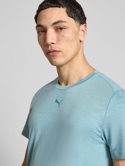 Männermodel trägt Regular Fit T-Shirt mit Logo-Print Modell 'Cloudspun' von PUMA PERFORMANCE in Hellblau, Nahaufnahme Oberkörper.