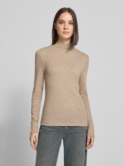 Frauenmodel trägt Langarmshirt mit Mock Neck Jersey von MARC O'POLO in melierter Beige-Optik, Strukturmuster, hochgeschlossen, Jersey-Material, Ganzkörperansicht von vorne.