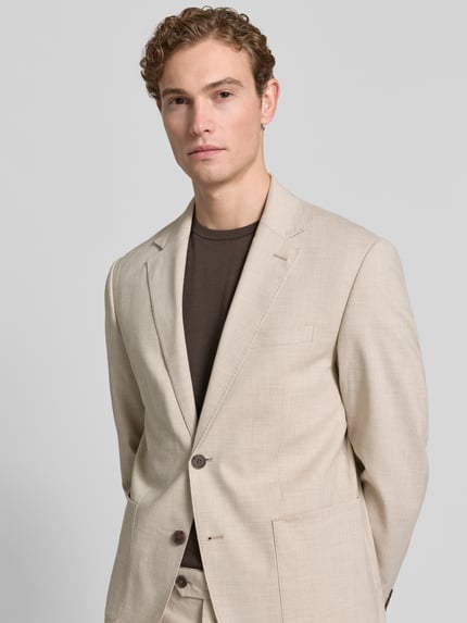Männermodel trägt Regular Fit Anzugsakko mit Leinen-Viskose-Anteil Modell 'DALI' von SELECTED HOMME, beige mit Allover-Muster, Nahaufnahme Oberkörper.