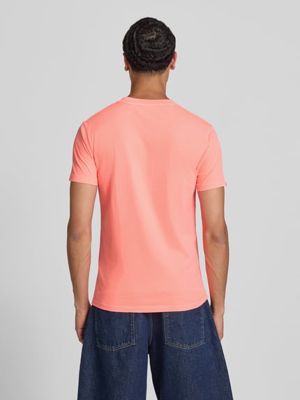 Männermodel trägt T-Shirt mit Rundhalsausschnitt und Label-Stitching von Superdry in Koralle, Reine Baumwolle, Slim-Fit, Rückenlänge 66 cm, Ganzkörperansicht Rückansicht.
