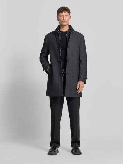 Männermodel trägt Mantel mit Stehkragen Modell '04073' von ROY ROBSON, unifarben, Struktur, Knöpfe, Gehschlitz, Longline, Ganzkörperansicht von vorne