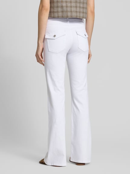 Frauenmodel trägt Regular Fit Bootcut Jeans aus Baumwoll-Mix Modell 'BLUSH' von Only, efekt: jednolity kolor, krój regular fit, krój bootcut z poszerzaną nogawką, średni stan, szlufki na pasek, zapięcie na guzik i ukryty zamek błyskawiczny, 5 kieszeni, wykończenie materiału: mieszanka bawełny, tkanina stylizowana na denim, kolor biały, Ganzkörperansicht Rückansicht.