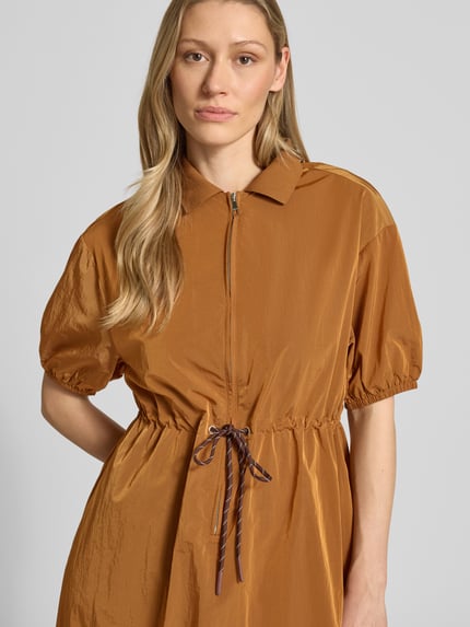 Vrouwenmodel draagt Midikleid met kurzem Reißverschluss und Kordelzug an der Taille van Rich & Royal, bruin, geribde kentkraag, getailleerde fit, korte ritssluiting, halve mouw met elastische boorden, taille met koord, detailopname bovenlichaam