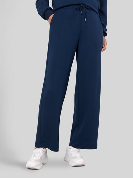 Frauenmodel trägt Sweatpants in verkürzter Passform von Soyaconcept, einfarbiges Dunkelblau, gerader Schnitt, Nahaufnahme Unterkörper.