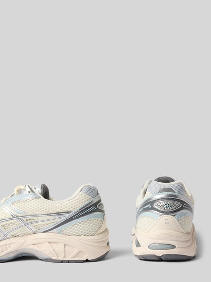 Produktfoto, Sneaker mit Label-Detail von ASICS TIGER, Material-Mix in Beige und Grau, strukturierte Sohle, abgerundete Passform, Rückansicht, Kontext: Damen Sneaker, Schnürverschluss, 4 cm Absatzhöhe, 8 cm Schafthöhe und Schaftweite.