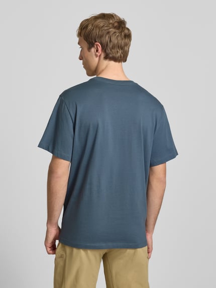 Męski model nosi T-Shirt mit Logo-Stitching von The North Face z bawełny, prosty krój, niebieski, widok całej sylwetki z tyłu.