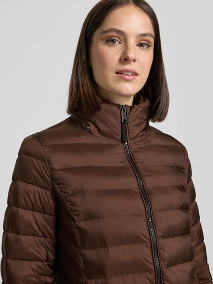Frauenmodel trägt Steppjacke mit Zweiwege-Reißverschluss von FUCHS SCHMITT in Braun, gesteppte Optik, Slim Fit, Nahaufnahme Oberkörper. Rückenlänge, Schulterbreite, Brustweite und Ärmellänge passend für Größe 36.
