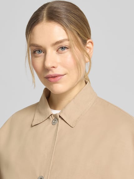 Vrouwenmodel draagt Blouson aus reiner Baumwolle van WHITE LABEL in beige met knoopsluiting, losse fit, kraag, detailopname bovenlichaam.