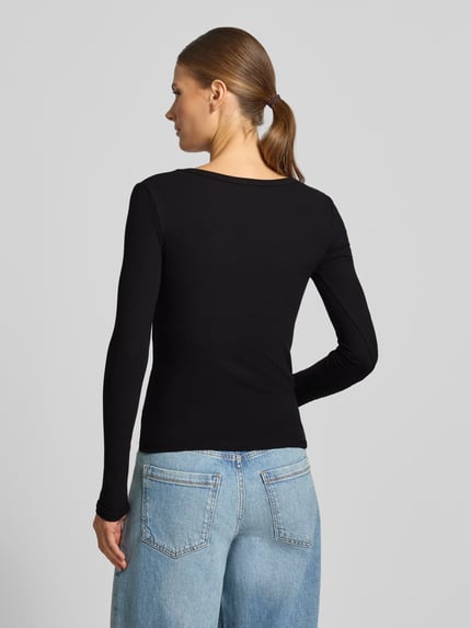 Frauenmodel trägt Longsleeve in Ripp-Optik Modell 'COLETTE' von GUESS Activewear, schwarzer Viskose-Elasthan-Mix, Rückansicht, Ganzkörperansicht Rückansicht.
