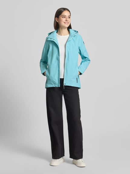 Frauenmodel trägt Parka mit Kapuze und verdecktem Reißverschluss von G.I.G.A. DX in Hellblau, Gerader-Schnitt, Label-Patch, Wasserabweisend, seitliche Reißverschlusstaschen, Rückenlänge 70 cm, Schulterbreite 41 cm, Brustweite 51 cm, Ärmellänge 63 cm, Ganzkörperansicht von vorne.