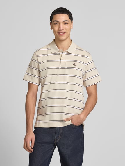Męski model nosi Regular Fit Poloshirt mit Logo-Stitching von Calvin Klein Jeans z bawełny, prążki, kołnierzyk polo, listwa guzikowa, długość tyłu 69 cm, Ganzkörperansicht von vorne.