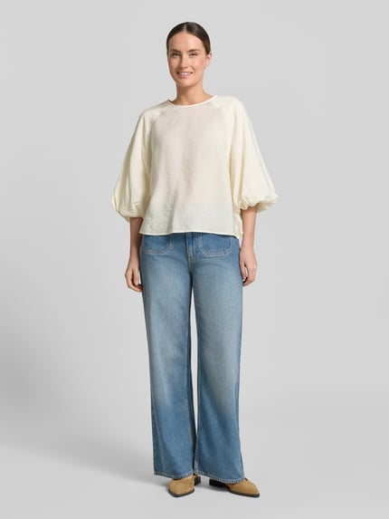 Frauenmodel trägt Regular Fit Bluse aus Viskose-Mix mit 3/4-Arm von Christian Berg Woman, cremefarben, weiche Textur, Ganzkörperansicht von vorne.